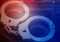 Handcuffs against pale red and blue background.