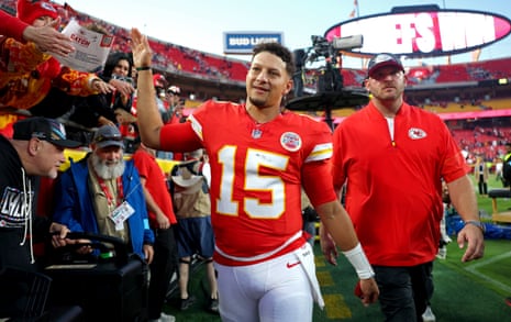 Patrick Mahomes waves and smiles while walking off the field past cheering fans