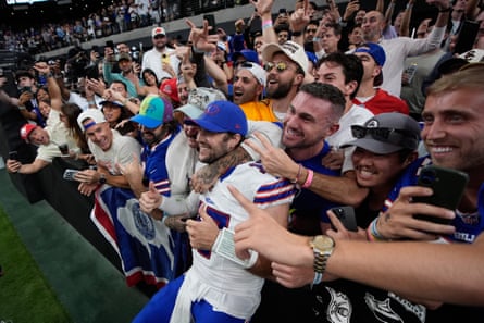 Josh Allen smiles among cheering Bills fans taking photos in the stadium