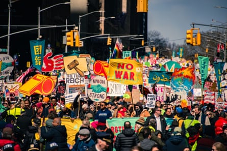 Crowds at a ‘No Kings’ protest hold colorful signs reading ‘No War’ and ‘Union Strong’.